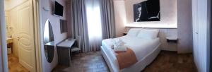 ein Hotelzimmer mit einem weißen Bett und einem Schreibtisch in der Unterkunft Hotel Locanda Dolce Vita in San Donà di Piave