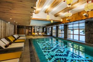 a swimming pool filled with lots of chairs and tables at Le Yule Hotel & Spa in Val-d'Isère