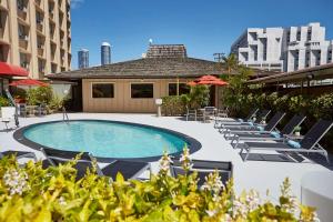 einen Pool mit Liegestühlen und Sonnenschirmen in der Unterkunft Pagoda Hotel in Honolulu