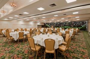 um salão de banquetes com mesas e cadeiras brancas em Pagoda Hotel em Honolulu