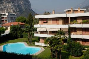 um edifício de apartamentos com uma piscina e uma montanha em Casa Lucia em Nago-Torbole