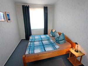 ペーネミュンデにあるFerienwohnung Peenemuende USE 2041のベッドルーム1室(木製ベッド1台、窓付)