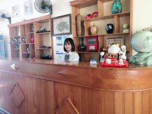 una mujer sentada en un mostrador en una tienda en Thành Trung Hotel, en Tuyên Quang