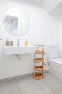 ein weißes Badezimmer mit einem Waschbecken und einem Spiegel in der Unterkunft Madeira Beach House - by LovelyStay in Madalena do Mar