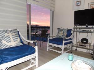 sala de estar con 2 sillas y TV en Departamento Playa Las Cadenas, en Algarrobo