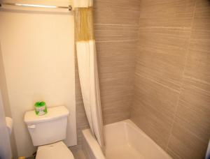 a bathroom with a toilet and a tub and a shower at Travel Inn in Phoenix