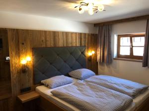 1 dormitorio con 1 cama con 2 almohadas en Berggasthof Obere Firstalm en Schliersee