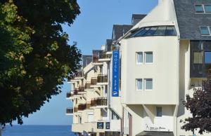 un bâtiment blanc avec un panneau bleu dans l'établissement Best Western Les Bains Hotel et SPA, à Perros-Guirec