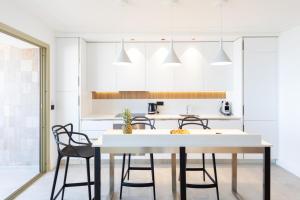 uma cozinha e sala de jantar com mesa e cadeiras em Center Bay Luxueux appartement avec vue mer 6 eme etage em Juan-les-Pins