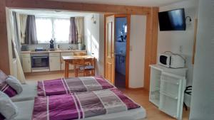 ein kleines Schlafzimmer mit einem Bett und einer Küche in der Unterkunft Apartments bei Familie Liebl in Sankt Oswald