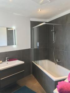 uma casa de banho com uma banheira e um lavatório em Apartment LUIZ em Schwaz