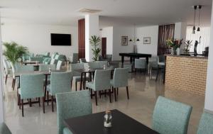 a restaurant with tables and chairs and a piano at Hotel Melius in Beja