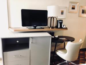 a computer desk with a monitor and a chair at Holiday Inn & Suites Pittsfield-Berkshires, an IHG Hotel in Pittsfield