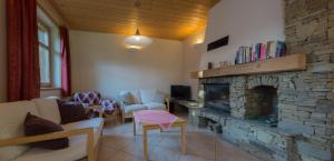 a living room with a stone fireplace and a couch at Sno House in Szczyrk