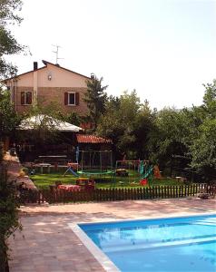 a swimming pool with a playground in a yard at Agriturismo Ca' Isotta in Castello di Serravalle