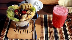 a bowl of fruit on a table with a drink at Inaki Uhi Hotel in Hanga Roa