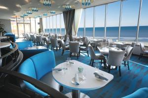 een restaurant met tafels en stoelen en de oceaan op de achtergrond bij Tropicana Casino and Resort in Atlantic City
