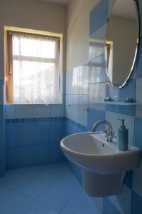 a blue bathroom with a sink and a mirror at Sno House in Szczyrk