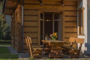 una mesa y dos sillas sentadas fuera de una cabaña en Sno House en Szczyrk