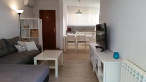 - un salon avec un canapé, une télévision et une table dans l'établissement Apartament Santa Marina, à Platja d'Aro