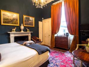 1 dormitorio con 1 cama, chimenea y ventana en Six Brunton Place Guest House, en Edimburgo