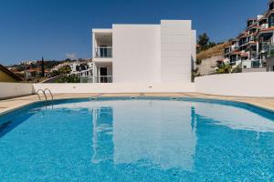 a large swimming pool in front of a building at Caniço VI by An Island Apart in Santa Cruz