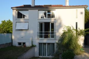 ein weißes Haus mit Fenstern und einem Zaun in der Unterkunft 23 Avenue Pasteur in Saint-Julien-du-Sault