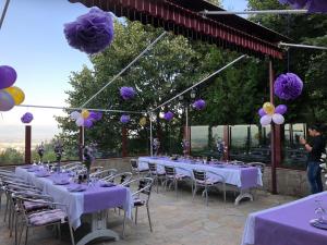 een groep tafels en stoelen met paarse decoraties bij Hotel - Restaurant Chairite in Sofia