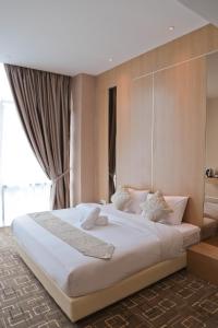 Cette chambre comprend un grand lit blanc et une fenêtre. dans l'établissement Top Holiday Hotel, à Seri Kembangan