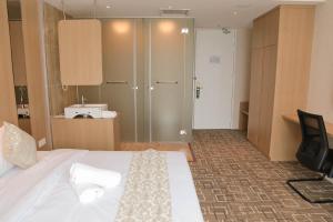 a hotel room with a bed and a glass door at Top Holiday Hotel in Seri Kembangan