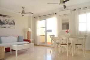 a living room with a table and chairs and a couch at Terrasol Baviera Golf in Caleta De Velez