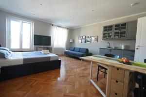 a bedroom with a bed and a kitchen with a table at Garibaldino Rooms in Trieste