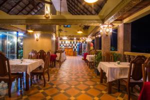 a restaurant with tables and chairs in a room at Hello Cambodia Boutique in Siem Reap