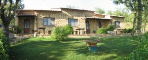 a house with a yard in front of it at Appartamento TRE QUERCE di Guerrini Mariella in Sorano