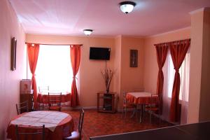 a room with two beds and a table and a window at Hotel Don Alfredo in Calama