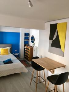 1 dormitorio con 1 cama, mesa y sillas en ATHENS *BLUE GRAND SUITE *DI GIORGIO CENTRAL APARTMENT en Athens