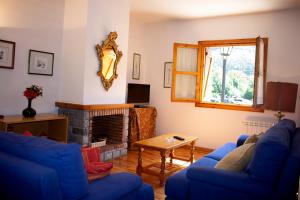 a living room with blue couches and a fireplace at Apartamentos Ball Benas Benasque in Benasque