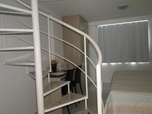 um quarto com uma escada em espiral ao lado de uma cama em Flat Jampa Cobertura Duplex A Beira Mar em João Pessoa