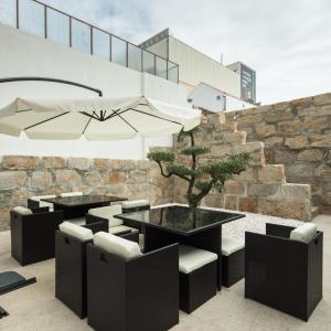 a patio with a table and chairs and a tree at Porto Deluxe Suites in Porto