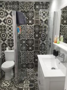 a bathroom with a toilet and a sink and a shower at Eden Suite in Eilat