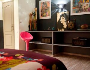 1 dormitorio con 1 cama con taburete rosa y estanterías en Chambre d'hôtes Au Fil de l'Eau, en Saint-Martin-Belle-Roche