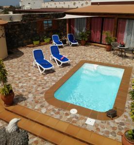 a patio with chairs and a swimming pool at Villa FranyMar in Lajares