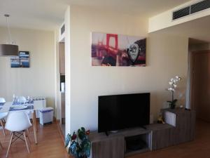 uma sala de estar com uma televisão de ecrã plano num suporte em Duplex em Santa María de Barbará