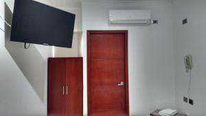 a room with a door and a flat screen tv at Hotel Manzanares Baranoa in Baranoa