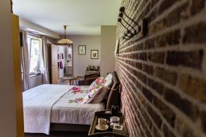 a bedroom with a brick wall and a bed at B&B 't Heirweggoed in Assenede