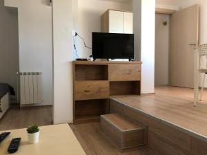 a living room with a television on a wooden entertainment center at Small & Sweet Apartments in Belgrade