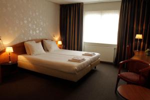 une chambre d'hôtel avec un lit et une fenêtre dans l'établissement De Vooroever, à Wervershoof