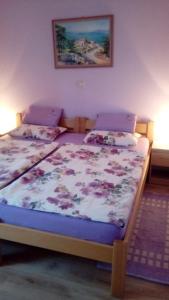 a bedroom with two twin beds with purple sheets at Raj Muraj Ferienappartement in Kornić
