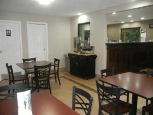 a dining room with tables and chairs and a counter at Super 8 by Wyndham Cincinnati-Springdale OH in Springdale