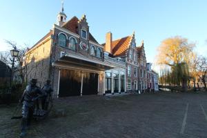 a statue of two men standing in front of a building at De Krasse Man in Edam